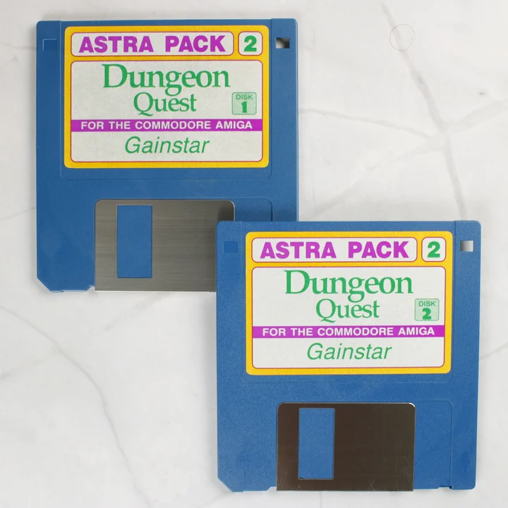 Két kék Amiga floppy lemez Dungeon Quest felirattal