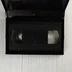 Nyitott VHS tok a fekete kazettával