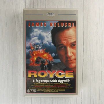 A Royce című film VHS borítójának előlapja James Belushi arcával és egy robbanó vonattal.