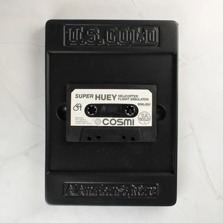 Super Huey C64 kazetta A Super Huey játék kazettája a fekete műanyag belső tálcában