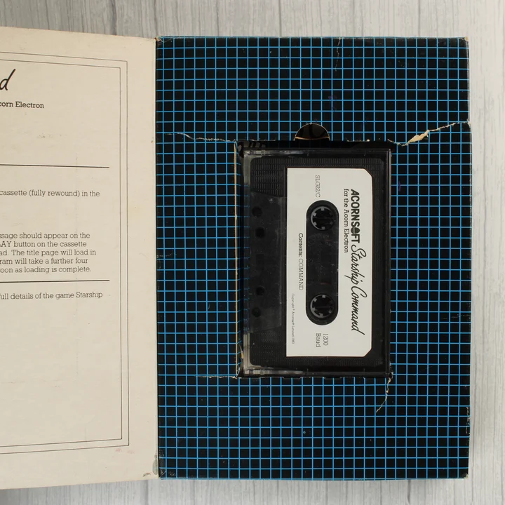 Starship Command kazetta és belső rész A nyitott doboz belseje a Starship Command kazettával és az útmutatóval