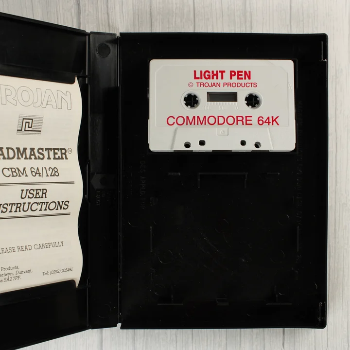 A nyitott tok a szoftverkazettával és a használati útmutatóval