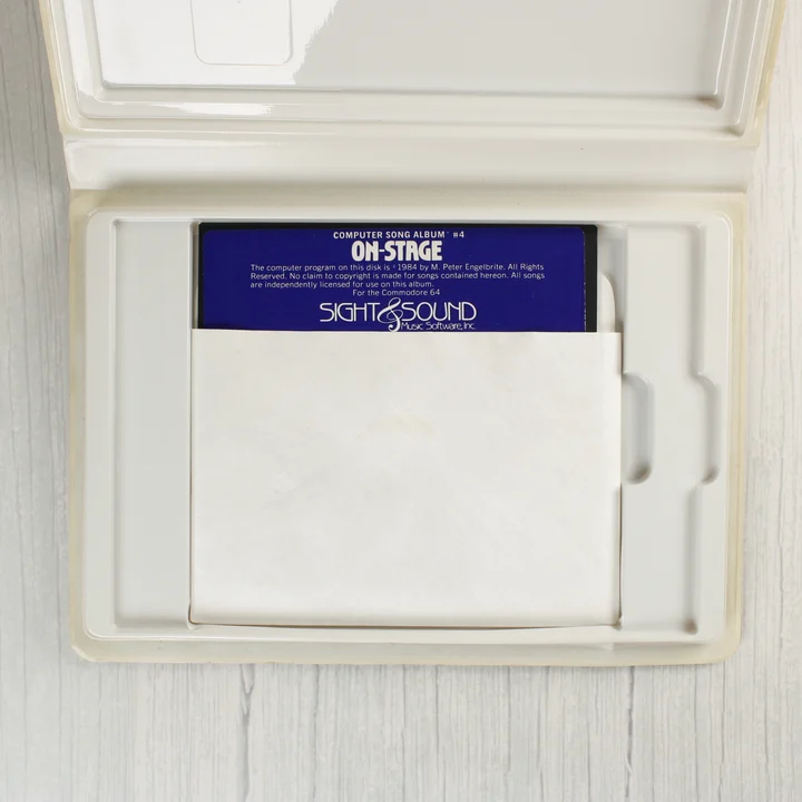 On Stage floppy lemez a tokban A nyitott műanyag tok, benne az 5,25 colos floppy lemezzel papírtokban.