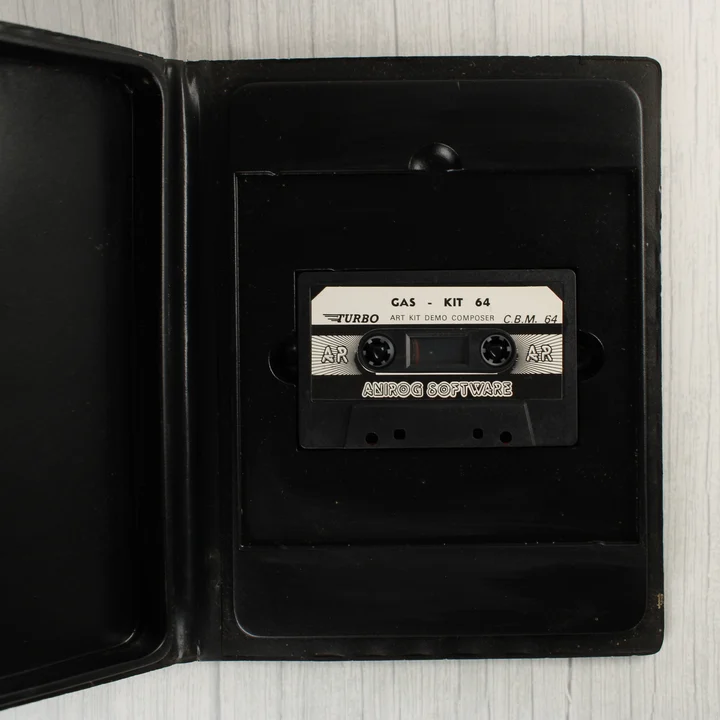 Nyitott szoftvertok a benne lévő fekete magnókazettával