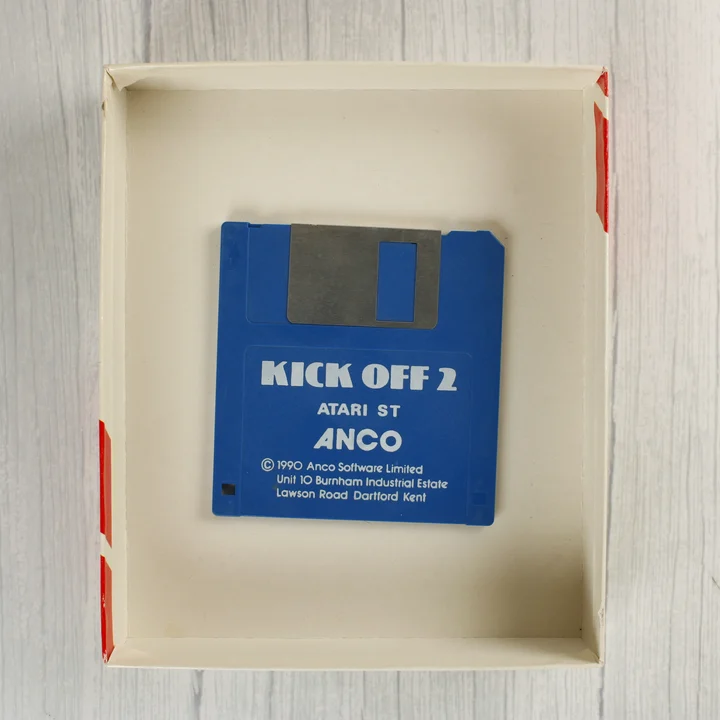 Kék színű 3,5 colos floppy lemez a Kick Off 2 felirattal a nyitott dobozban