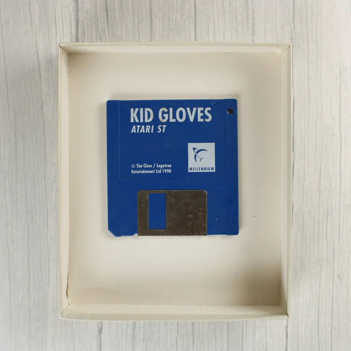 Kék színű 3,5 colos floppy lemez a Kid Gloves játék feliratával a dobozban.