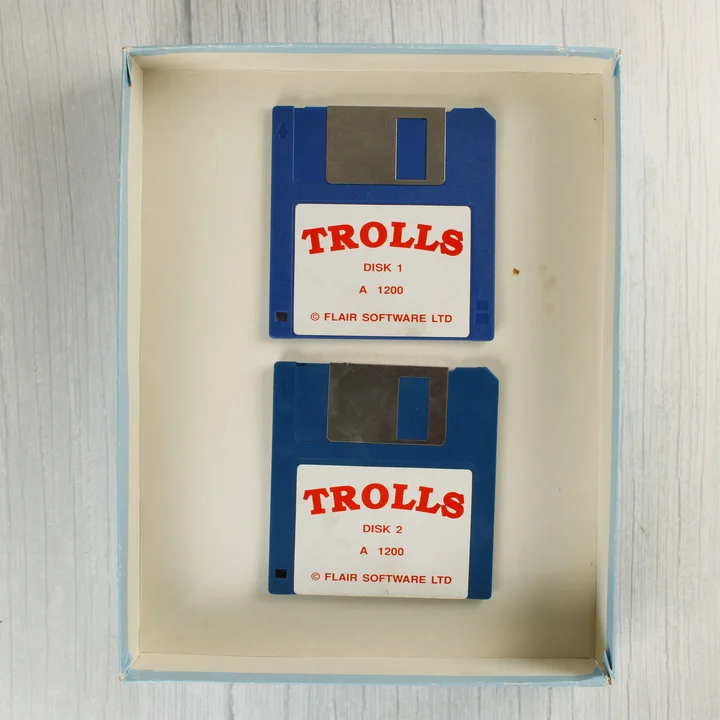Két kék floppy lemez a Trolls videójátékhoz a dobozban