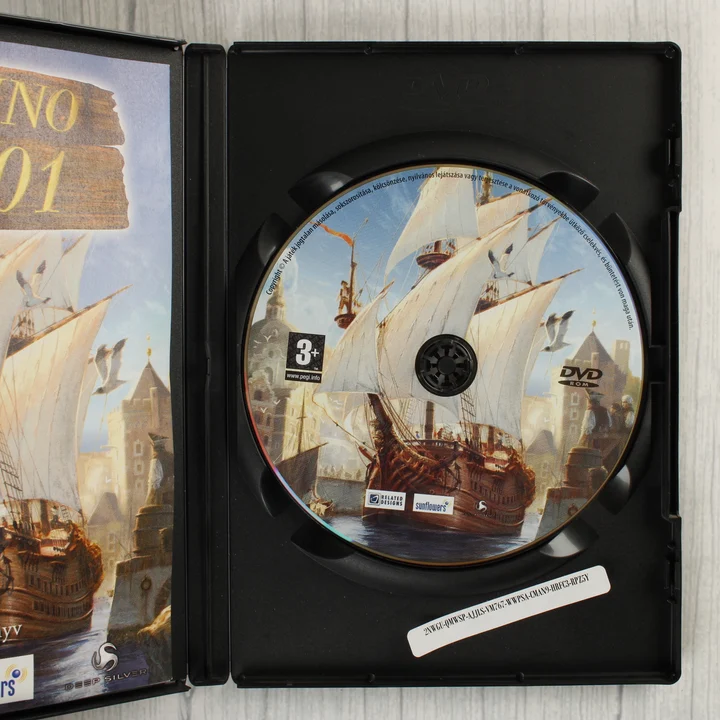 Nyitott DVD-tok az Anno 1701 lemezzel és kézikönyvvel