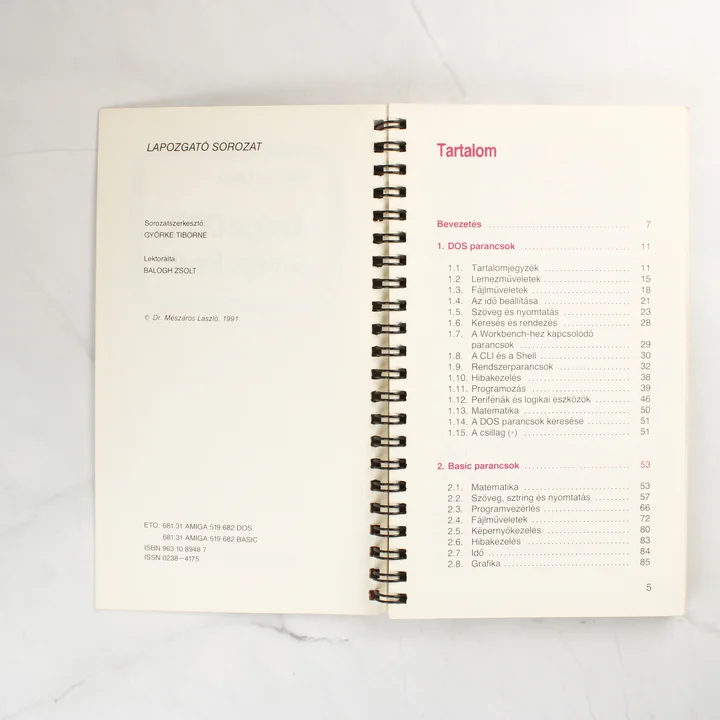 A könyv nyitott állapota a tartalomjegyzéknél, látható a spirálkötés és a kiadási adatok.