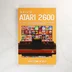 The A-Z of the Atari 2600 könyv előlapja narancssárga háttérrel és a konzol képével