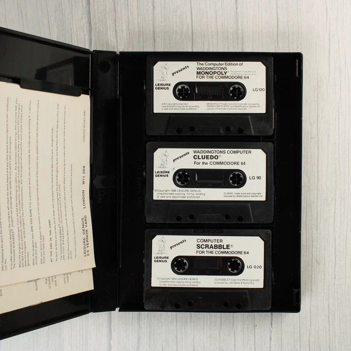 A nyitott tok belseje a három fekete kazettával és a használati útmutatóval