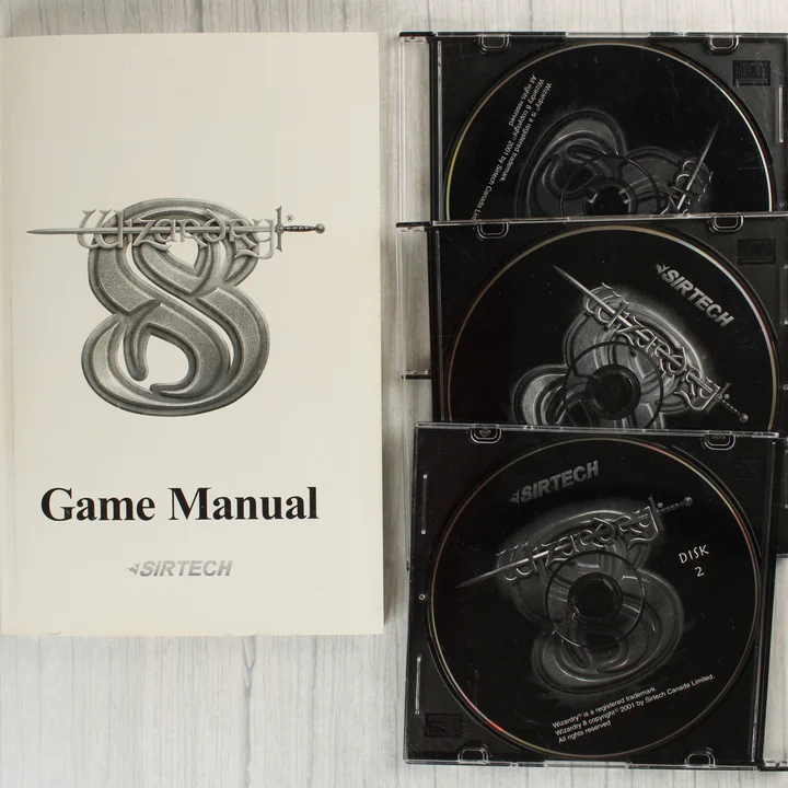A Wizardry 8 játék kézikönyve és a három CD-lemez műanyag tokban.