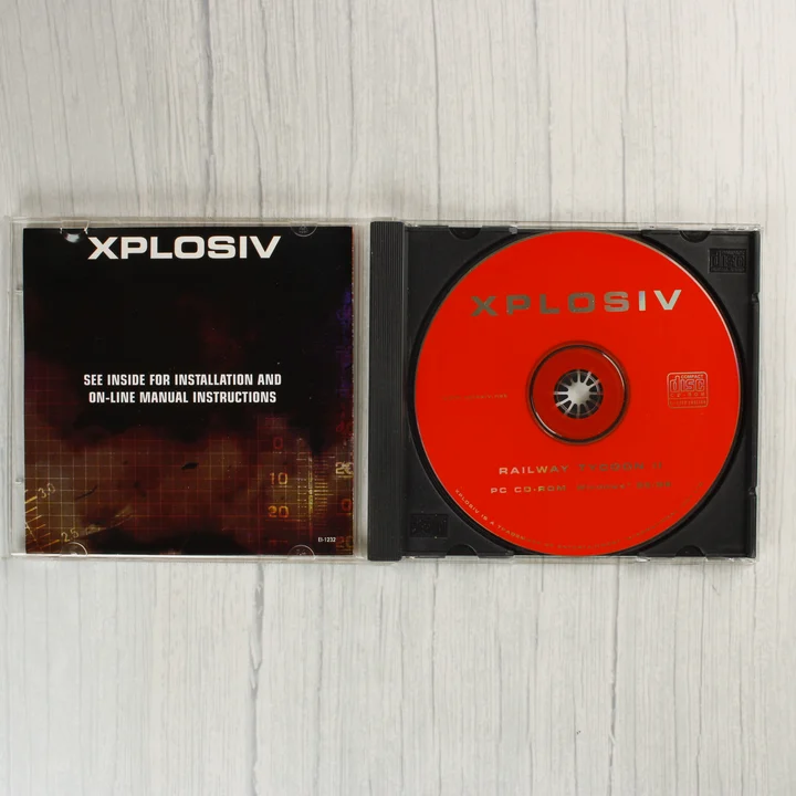 Nyitott CD-tok a Railroad Tycoon II piros lemezével és a kísérőfüzettel