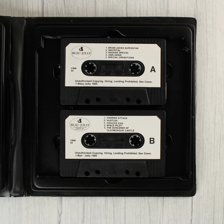 Két fekete magnókazetta a 10 Computer Hits válogatás nyitott tokjában