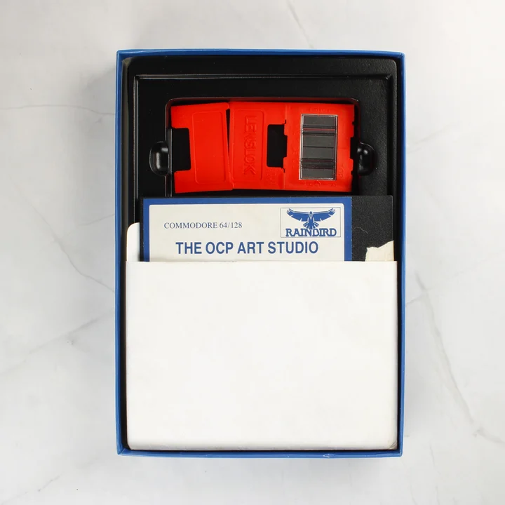 The OCP Art Studio szoftver dobozának tartalma floppy lemezzel és Lenslok eszközzel