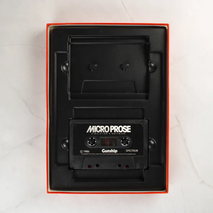 A videójáték dobozának belseje a fekete kazettával és a műanyag tálcával