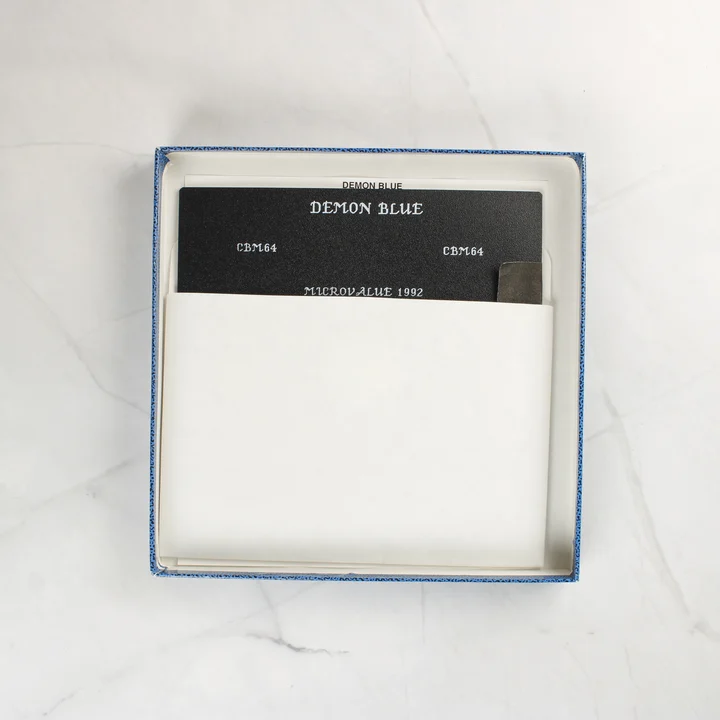 A nyitott doboz belseje egy 5,25 colos floppy lemezzel fehér papírtokban.