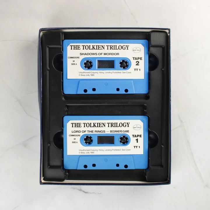 Két kék színű Commodore 64 kazetta a fekete műanyag tartóban