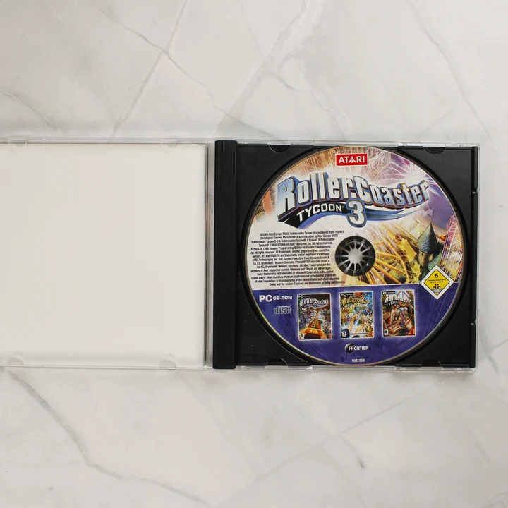RollerCoaster Tycoon 3 Deluxe Edition nyitott CD-tok a lemezzel