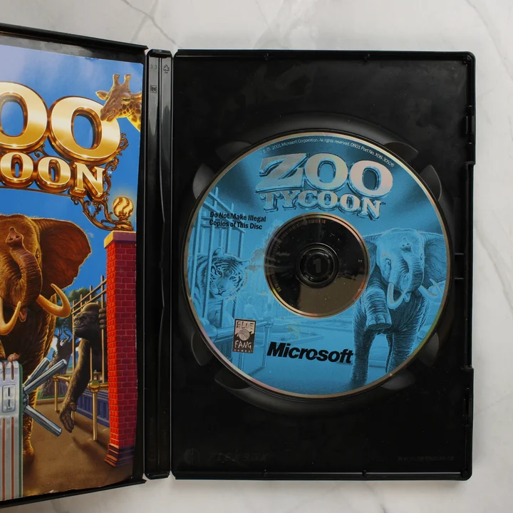A nyitott tokban lévő Zoo Tycoon CD-lemez és a belső borító.