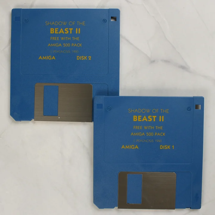 Két kék Amiga floppy lemez a Shadow of the Beast II játékkal