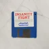 Kék színű 3,5 colos floppy lemez Insanity Fight felirattal.