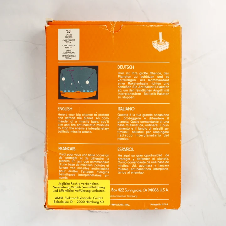A Missile Command videójáték dobozának hátoldala többnyelvű leírással.