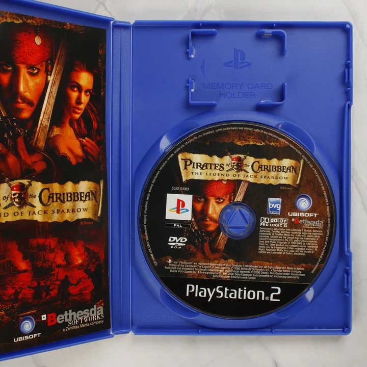 Nyitott PS2 tok a Pirates of the Caribbean lemezzel és kiskönyvvel