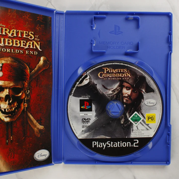 Nyitott PlayStation 2 tok a Pirates of the Caribbean lemezzel és kézikönyvvel