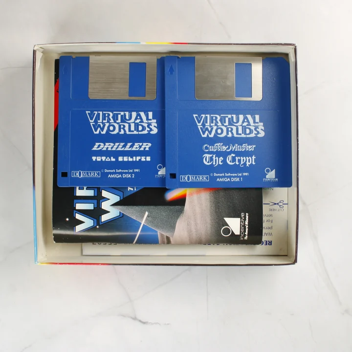 Két kék floppy lemez a Virtual Worlds játékgyűjteményből a nyitott dobozban