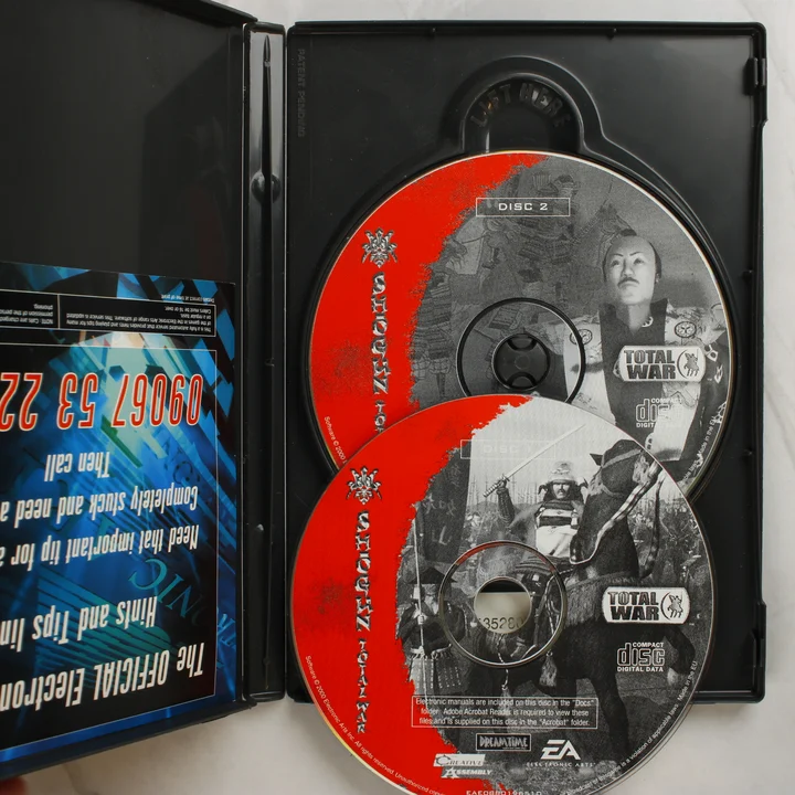 Nyitott tok két Shogun: Total War CD-ROM lemezzel és egy információs kártyával.
