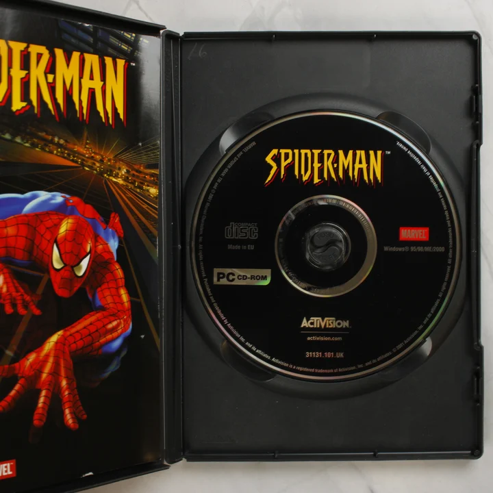 Nyitott Spider-Man videójáték tok a lemezzel és a füzettel