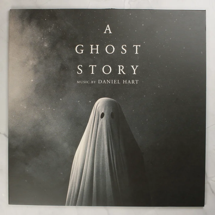A Ghost Story filmzene bakelit lemez borítója egy szellemalakkal