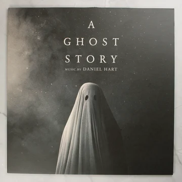 A Ghost Story filmzene bakelit lemez borítója egy szellemalakkal