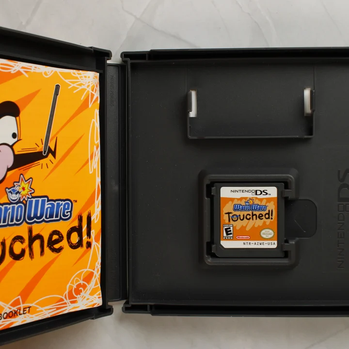 Nyitott Nintendo DS tok a WarioWare Touched! cartridge-dzsel