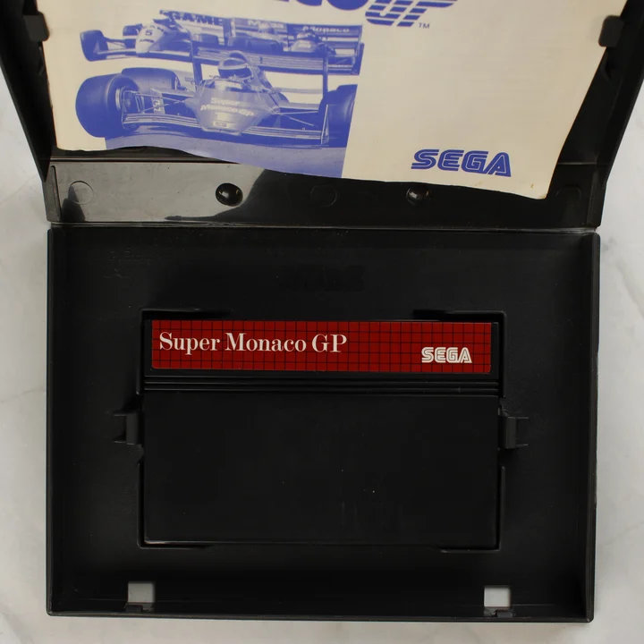 Nyitott Super Monaco GP játéktok a cartridge-el és az útmutatóval