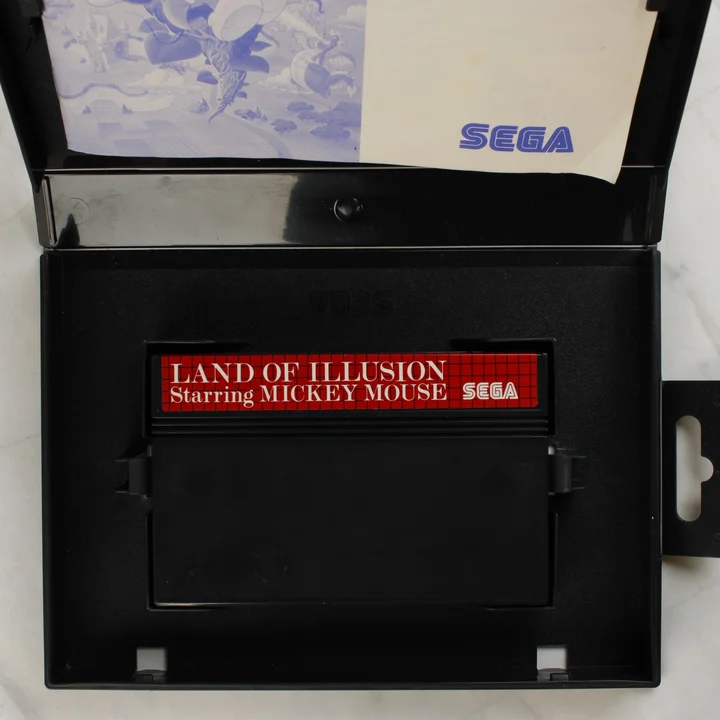 Nyitott Sega Master System tok a Land of Illusion cartridge-dzsel és útmutatóval