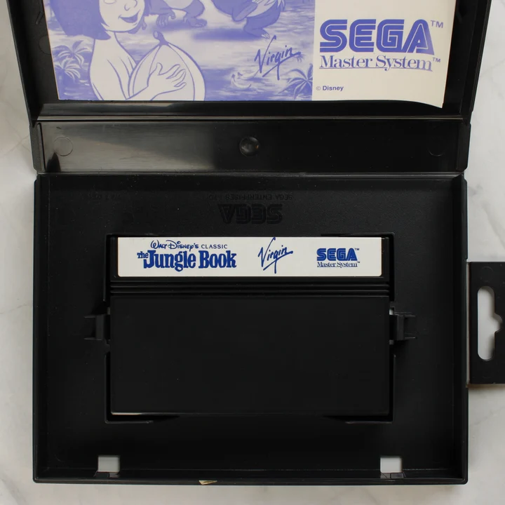 Nyitott Sega Master System tok a cartridge-dzsel és a kiskönyvvel