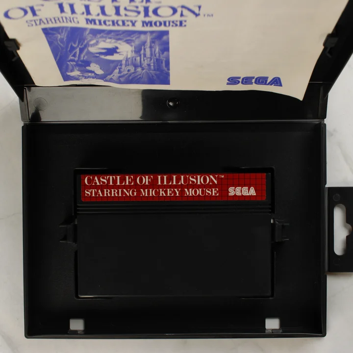 Nyitott Sega Master System tok a Castle of Illusion cartridge-dzsel