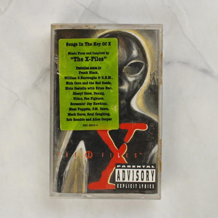 Songs In The Key Of X X-akták magnókazetta elölnézete zöld matricával