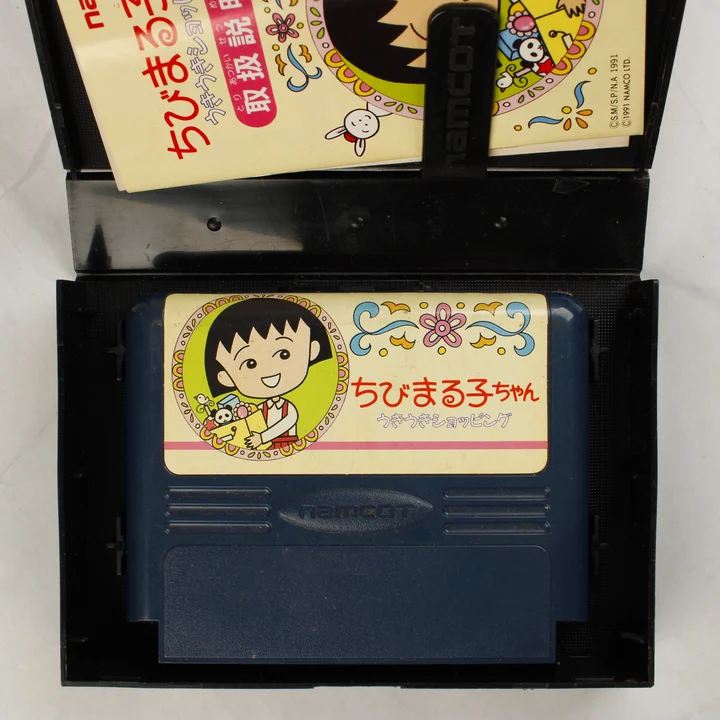 Nyitott doboz a Chibi Maruko-chan cartridge-dzsel és kézikönyvvel