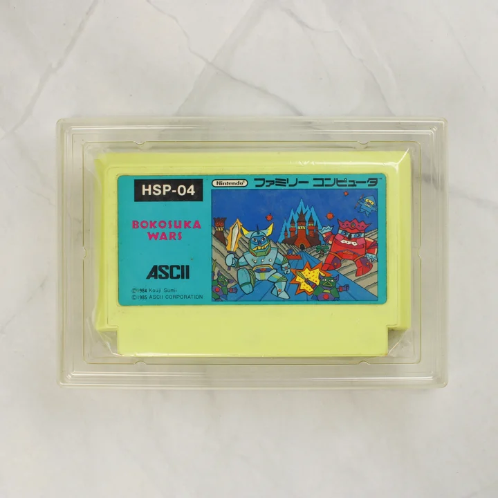 Bokosuka Wars sárga Famicom cartridge műanyag tálcában