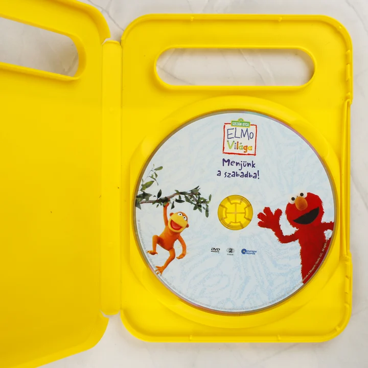 Elmo világa DVD lemez Nyitott sárga DVD tok a benne lévő Elmo világa lemezzel