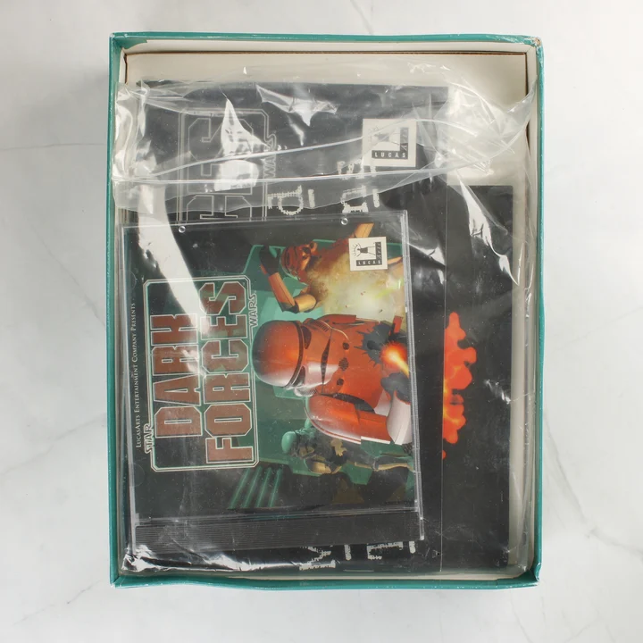 A nyitott játékdoboz tartalma, benne a CD-tokkal és kézikönyvvel