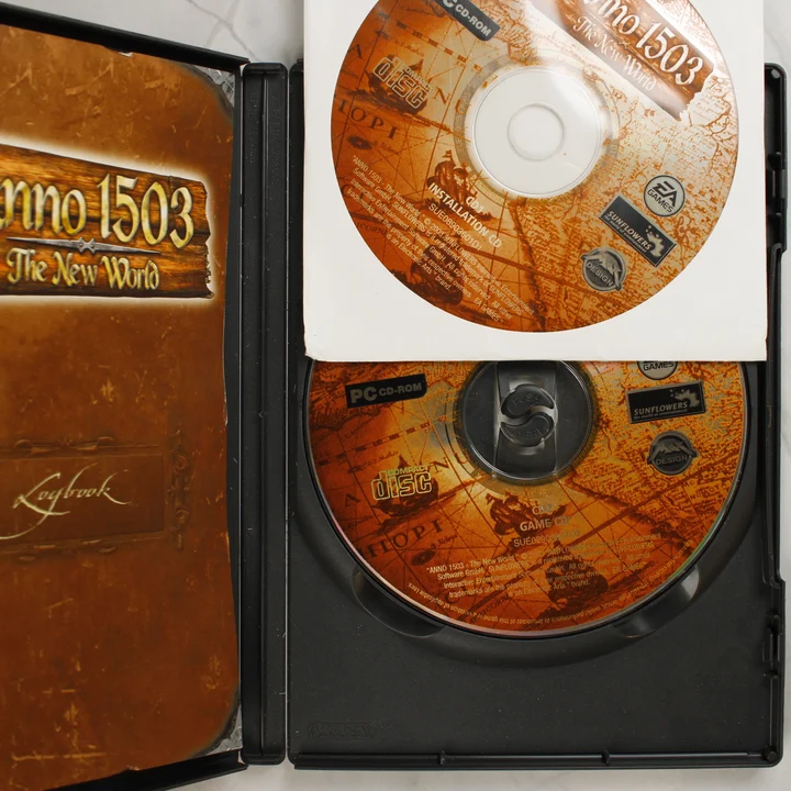 Anno 1503 PC tartalom Az Anno 1503 nyitott tokja a két CD-vel és a kézikönyvvel