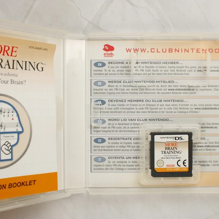 Nyitott Nintendo DS tok a cartridge-dzsel és az útmutatóval
