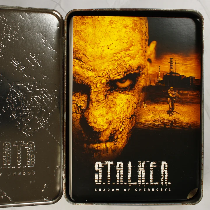 Nyitott fémdoboz a S.T.A.L.K.E.R. túlélési útmutatóval