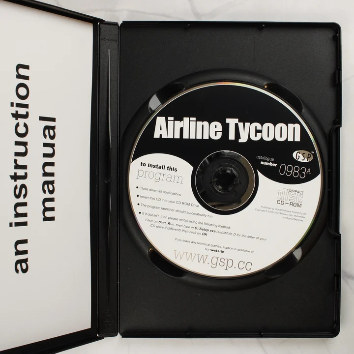 Airline Tycoon CD és belső Az Airline Tycoon nyitott tokja a CD-ROM lemezzel és az útmutatóval
