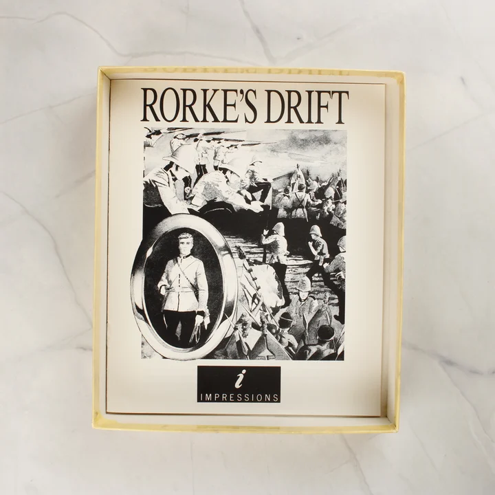Rorke's Drift kézikönyv A Rorke's Drift játék fekete-fehér kézikönyve a nyitott dobozban