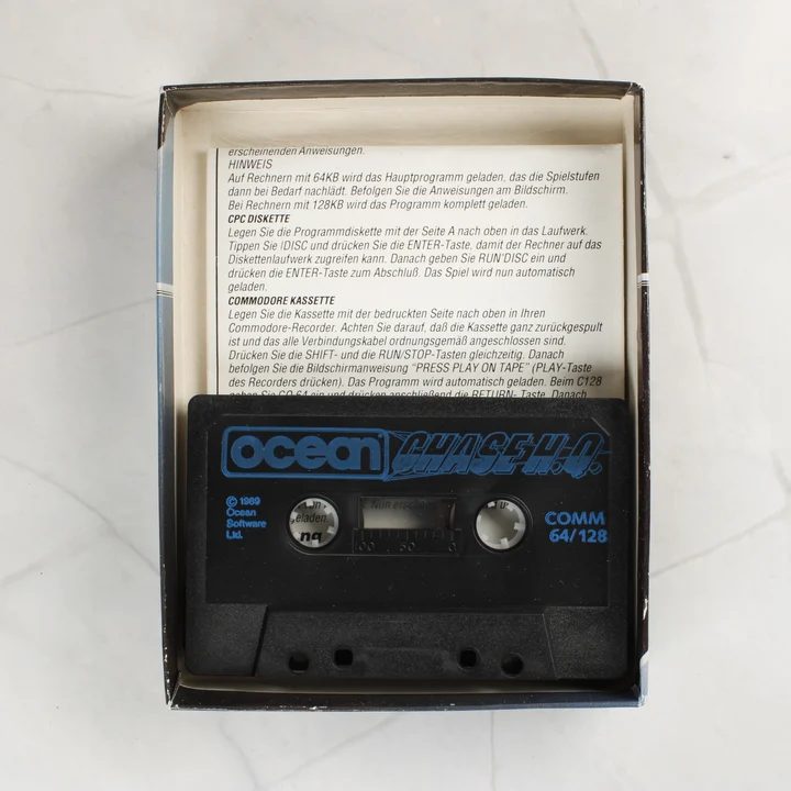 Nyitott doboz benne a fekete kazettával és a papír útmutatóval